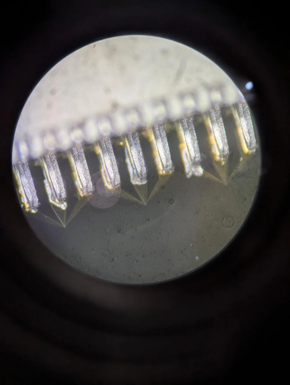 Microscope view of connector pins soldered to the wafer surface